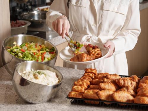 a chef holding a plate of food on a counter at the b sapporo in Sapporo