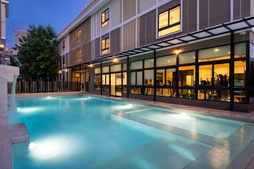 a large swimming pool in front of a building at Amanah Bangkok Hotel in Bangkok