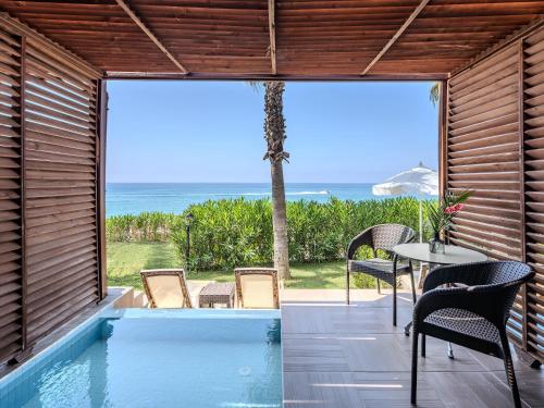 a house with a pool and a table and chairs at Adora Calma Beach Hotel Adults Only in Kızılot