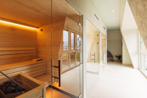 a sauna with a glass wall in a house at harry's home Lienz hotel & apartments in Lienz