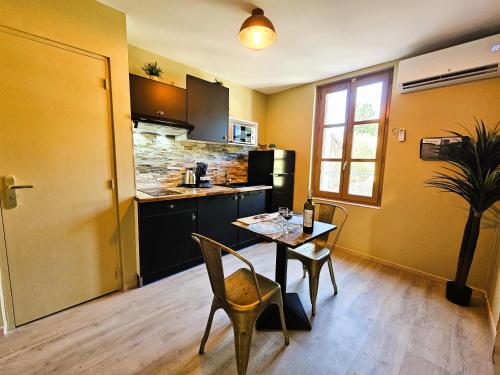 une cuisine avec une table et des chaises ainsi qu'une salle à manger dans l'établissement Tout confort ! Ville, Calme, Cinéma privé, Climatisation, Parking, WiFi, à Carcassonne