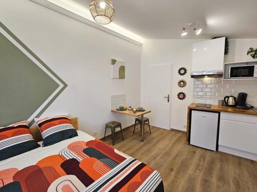 une chambre avec un lit et une petite cuisine dans l'établissement Tout confort ! Ville, Climatisation, Parking, Wifi, Calme, TV, à Carcassonne