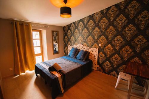 une chambre avec un lit avec une couette bleue et une fenêtre dans l'établissement Tout confort ! Ville, Calme, Cinéma privé, Climatisation, Parking, WiFi, à Carcassonne