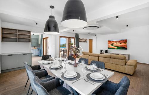 a dining room and living room with a table and chairs at Nice Home In Zaboric With Wifi in Zaboric