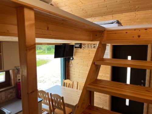 a loft bed in a tiny house at Tõhela Järve Puhkeküla in Männikuste