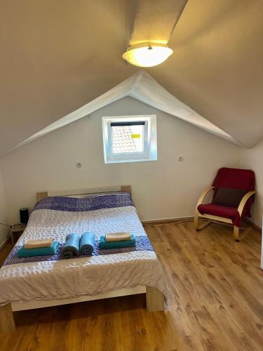 a bedroom with a bed and a red chair at Roman Arch- low budget doublebed room in top center in Pula