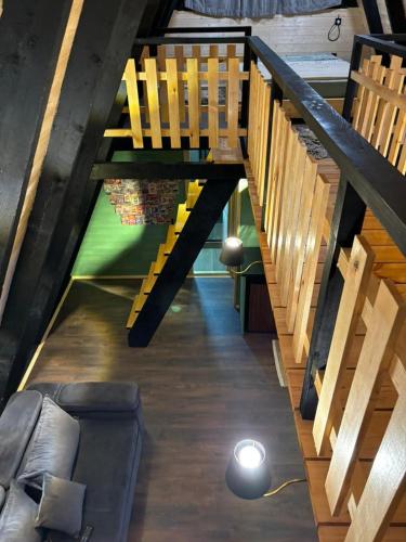 a living room with wooden stairs and a couch at Cottage Sataplia in Kutaisi