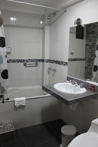 a bathroom with a sink and a tub and a mirror at Hotel Tierra Inka Sacred Valley in Ollantaytambo