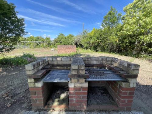 an outdoor brick oven with a bench in a field at Kujukuri Green Garden Villa - 九十九里 グリーンガーデン - in Yokoshibahikari