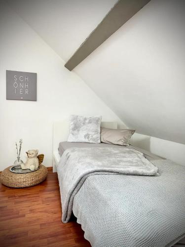 a white bedroom with a bed and a teddy bear at Pures Wohlfühlen mit privater Sauna & Garten in Meschede