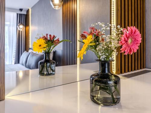 two vases filled with flowers sitting on a table at Adora Calma Beach Hotel Adults Only in Kızılot