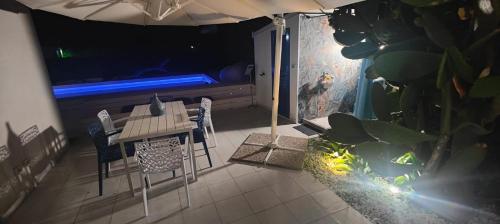 a patio with a table and chairs and an aquarium at Pool Seaside Relais - VILLE Ninfea, Marea, Rosa e Cassiopea in Fontane Bianche
