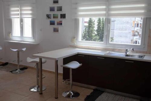 cocina con fregadero, mesa y 2 taburetes en Photo gallery apartment, en Kavala