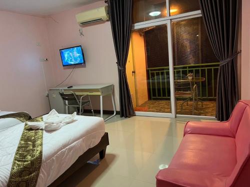 a hotel room with a bed and a chair and a window at โรงแรมตะวันไท in Ban Krabi Yai