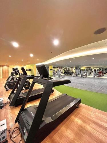 a gym with a row of treadmills and exercise equipment at E & R Staycation Condotel near Mall of Asia in Manila