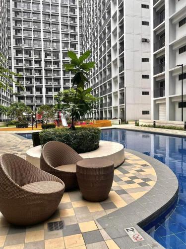 a courtyard with chairs and a pool in a building at E & R Staycation Condotel near Mall of Asia in Manila