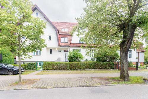 two trees in front of a white building at Villa Superiq Victus Sopot Walk to the Pier by Noclegi Renters in Sopot