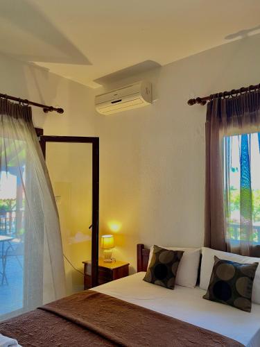 a bedroom with a bed and a large window at Anna Dani Apartments in Vourvourou