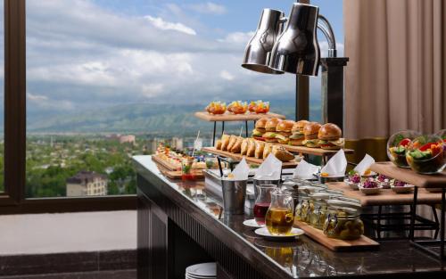 a buffet with food on a table with a view at Hilton Dushanbe in Dushanbe