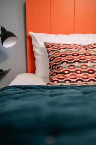 a bedroom with a bed with a pillow and a lamp at Strandvogtei Sylt in Rantum