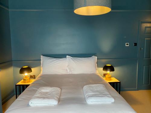 a bed with two pillows on it with two lamps at ROOMS AT THE QUAYSIDE - stylish en-suite rooms on Poole Quay all fully refurbed in Poole