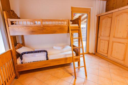 two bunk beds in a room with a ladder at Bergidyll 5 by Alpenidyll Apartments in Ramsau am Dachstein
