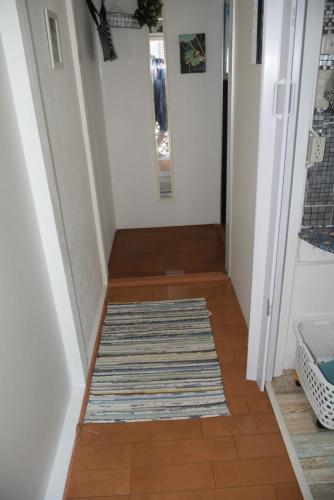 a hallway with a rug on a tile floor at EMS Enoshima クラシックゲストハウス 寝室は個室 犬OK in Fujisawa
