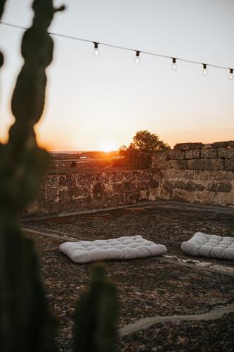 two pillows on the ground with the sunset in the background at Galeta Masseria in Nardò