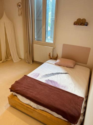 un petit lit dans une chambre avec une fenêtre dans l'établissement Maison familiale avec véranda, à Vallauris