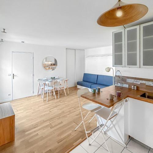 Il comprend une cuisine et un salon doté d'un canapé bleu. dans l'établissement L'Éclat de Serris Proche Disney, à Serris