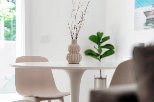 a white table with a vase on top of it at Lario Suite Apartments by Quokka 360 - With parking Next to Como City in Como