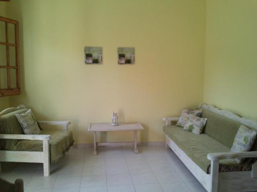 a living room with a couch and a table at Olga's Garden Apartments in Almiros Beach