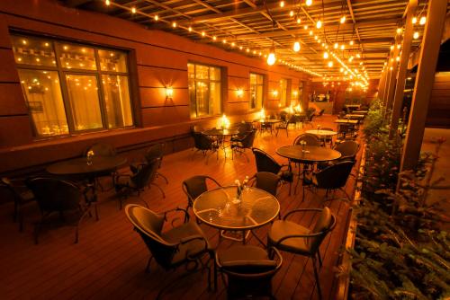 an empty restaurant with tables and chairs at night at Ulaanbaatar Hotel in Ulaanbaatar