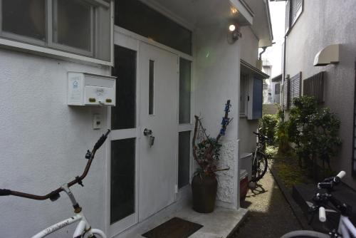 an alley with two bikes parked next to a door at EMS Enoshima クラシックゲストハウス 寝室は個室 犬OK in Fujisawa