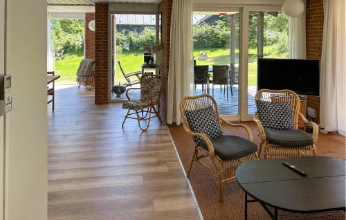 a living room with chairs and a table and a television at Two-Bedroom Holiday Home In Knebel in Knebel