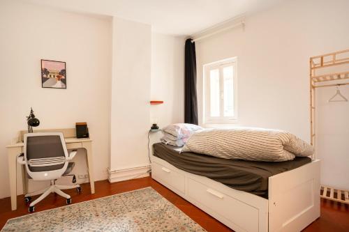 a bedroom with a bed and a desk and a chair at La Vaca superbe T3 Climatisation Wifi Netflix Coeur Historique in Béziers