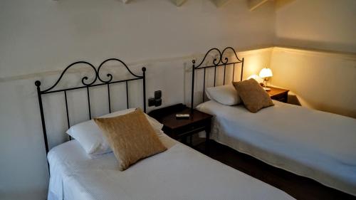 Dos camas una al lado de la otra en una habitación. en Villa Evdokia, en Symi
