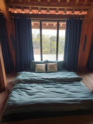 a bed in a room with a window at Hill House in Mai Chau