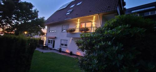 a white house with a balcony with lights on it at Renatas Ferienwohnung Wohnung David in Sasbachwalden