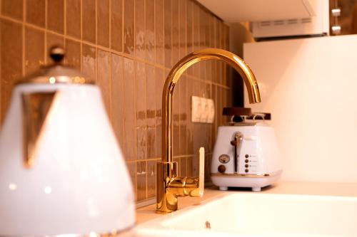 a kitchen sink with a gold faucet and a toaster at Holiday Home Skala with hot tub & Kala with terrace in Pitve