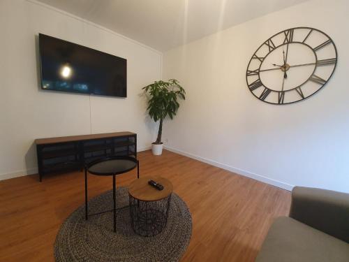 un salon avec une horloge au mur et un tabouret dans l'établissement La citadine, à Cholet