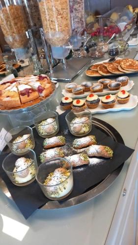 a buffet with many different types of food and cupcakes at Hotel Porta Reale in Noto