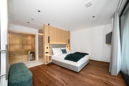 a bedroom with a bed and a television in it at Anna Lodges Dolomites in Santa Cristina in Val Gardena