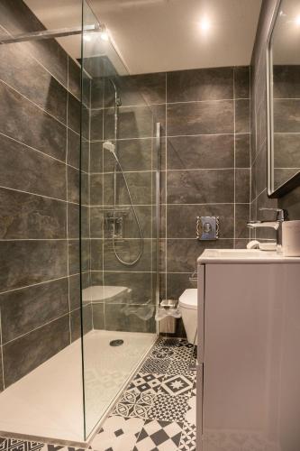 une salle de bain avec une douche en verre et des toilettes dans l'établissement La Vaca T3 Standing Climatisation Wifi Netflix Coeur Historique, à Béziers