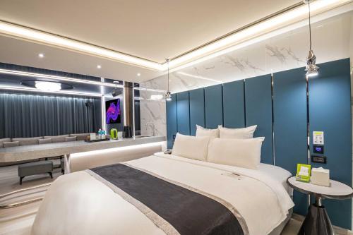 a bedroom with a large bed with a blue wall at 168 Motel-Zhongli in Zhongli
