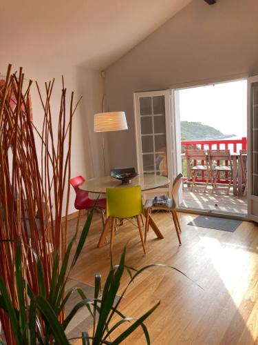 une salle à manger avec une table et des chaises et un balcon dans l'établissement VILLA ETCHE CAROLA BIDART - Le peintre Appartement 1er Étage, à Bidart