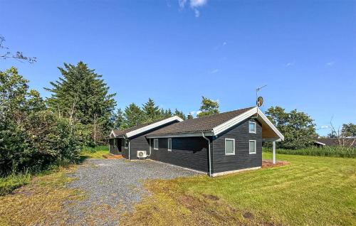 a small house with a garage in a yard at Holiday Home Nørtvedvej Strandby Denm in Strandby