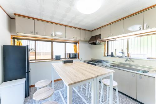 a kitchen with white cabinets and a wooden table at Sakurahotei - 桜歩亭 in Sengokuhara