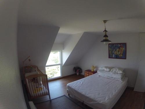 une chambre avec un lit blanc et une fenêtre dans l'établissement Maison vue mer imprenable, à Groix