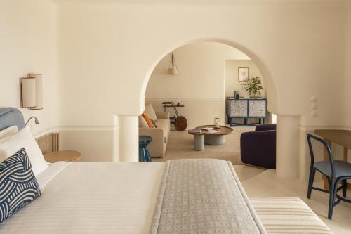 a bedroom with a bed and a living room at Homeric Poems in Fira